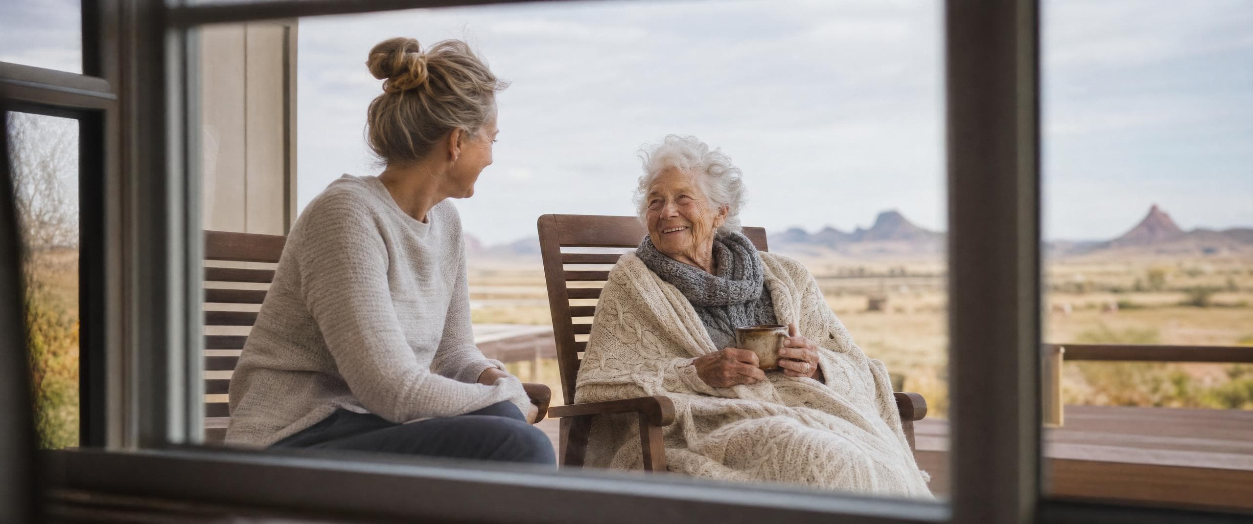 Ativo caregiver visiting with a senior on a back porch overlooking the Arizona desert